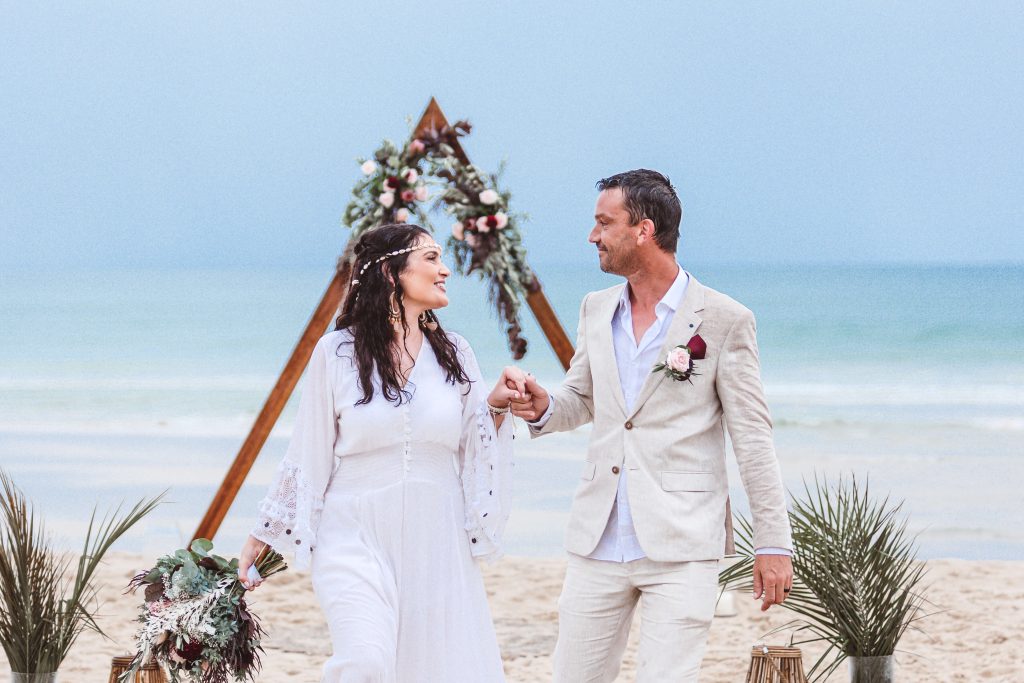 Bride & Groom holding hands on the beach in noosa after wedding