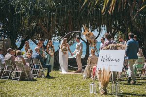 Close-up of Zoe and Deon during their Oceanic Dream package wedding ceremony on the lush green lawn by the ocean.