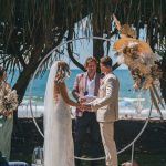 Close-up of Zoe and Deon during their Oceanic Dream package wedding ceremony on the lush green lawn by the ocean.