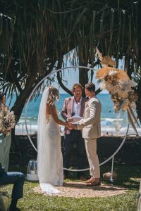 Close-up of Zoe and Deon during their Oceanic Dream package wedding ceremony on the lush green lawn by the ocean.