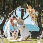 Close-up of Zoe and Deon during their Oceanic Dream package wedding ceremony on the lush green lawn by the ocean.