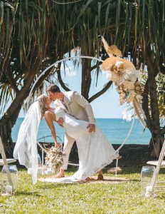 Close-up of Zoe and Deon during their Oceanic Dream package wedding ceremony on the lush green lawn by the ocean.