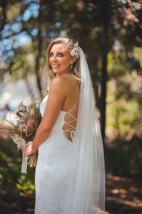 Close-up of Zoe during their Oceanic Dream package wedding ceremony on the lush green lawn by the ocean.