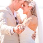 Close-up of Zoe and Deon during their Oceanic Dream package wedding ceremony on the lush green lawn by the ocean.