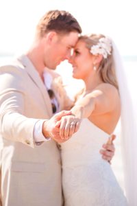 Close-up of Zoe and Deon during their Oceanic Dream package wedding ceremony on the lush green lawn by the ocean.