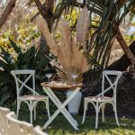 Luxe white circle arbour with neutral-colored dried florals against the ocean backdrop at Zoe and Deon’s Noosa wedding.v