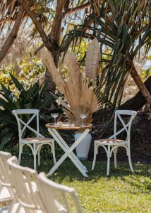 Luxe white circle arbour with neutral-colored dried florals against the ocean backdrop at Zoe and Deon’s Noosa wedding.v